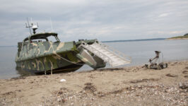Led by the Naval Surface Warfare Center Indian Head Explosive Ordnance Disposal Technology Division, this simulated mission involves deploying Explosive Ordnance Disposal Unmanned Ground Vehicle (UGV) assets from a converted autonomous Advanced Composite